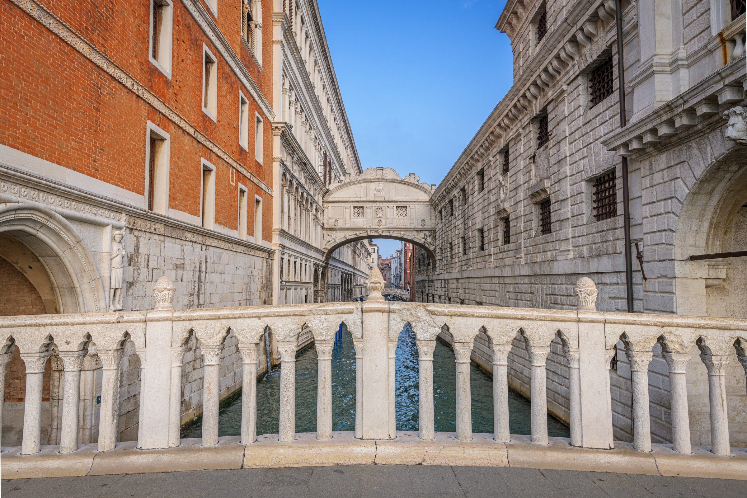 Bridge of Sighs di Venice dilihat dari pagar jembatan dengan langit biru.