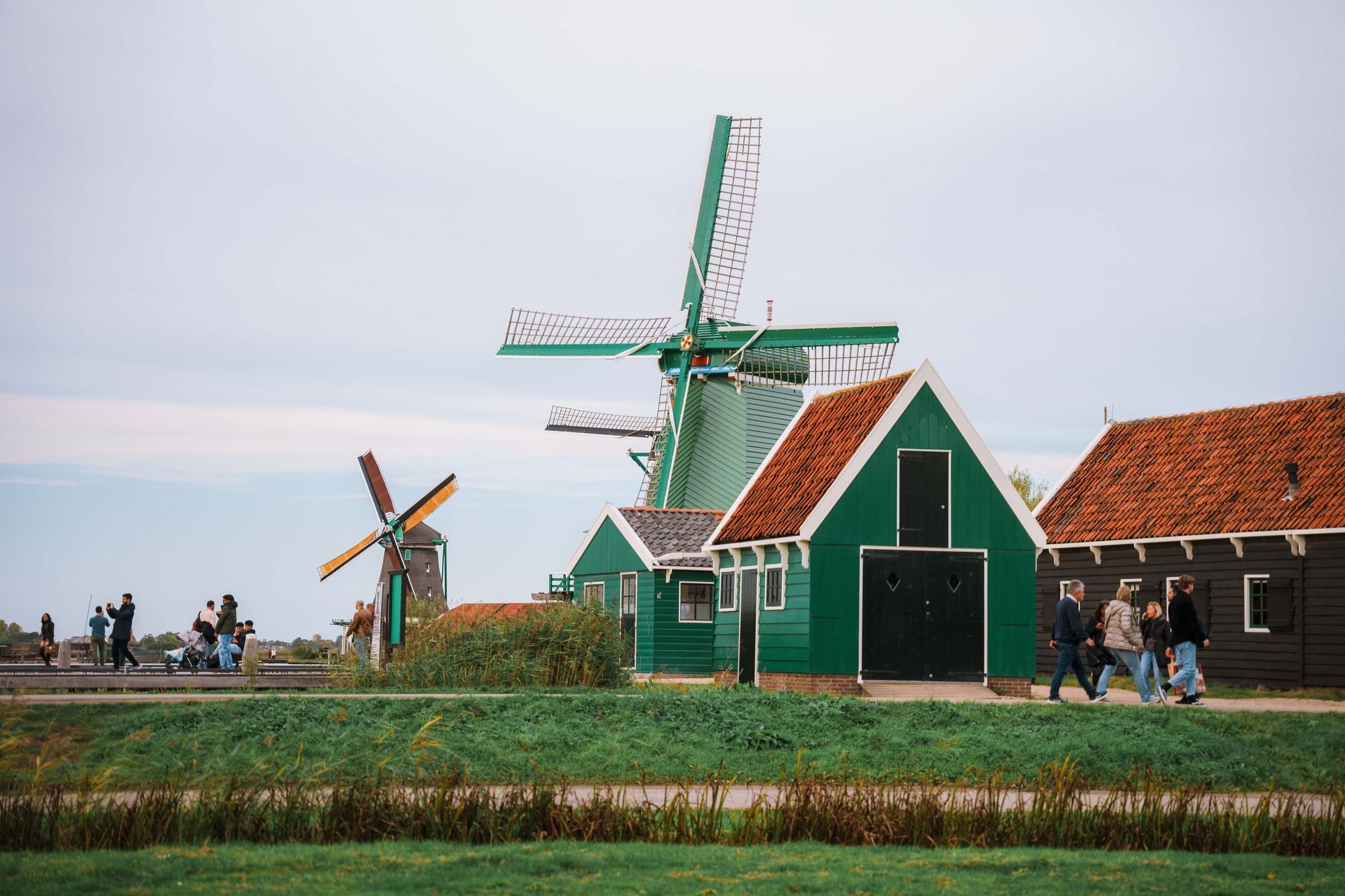 Ibu Wulan: Jalan di antara kincir angin Zaanse Schans pakai clog kayu belanja di toko suvenir.