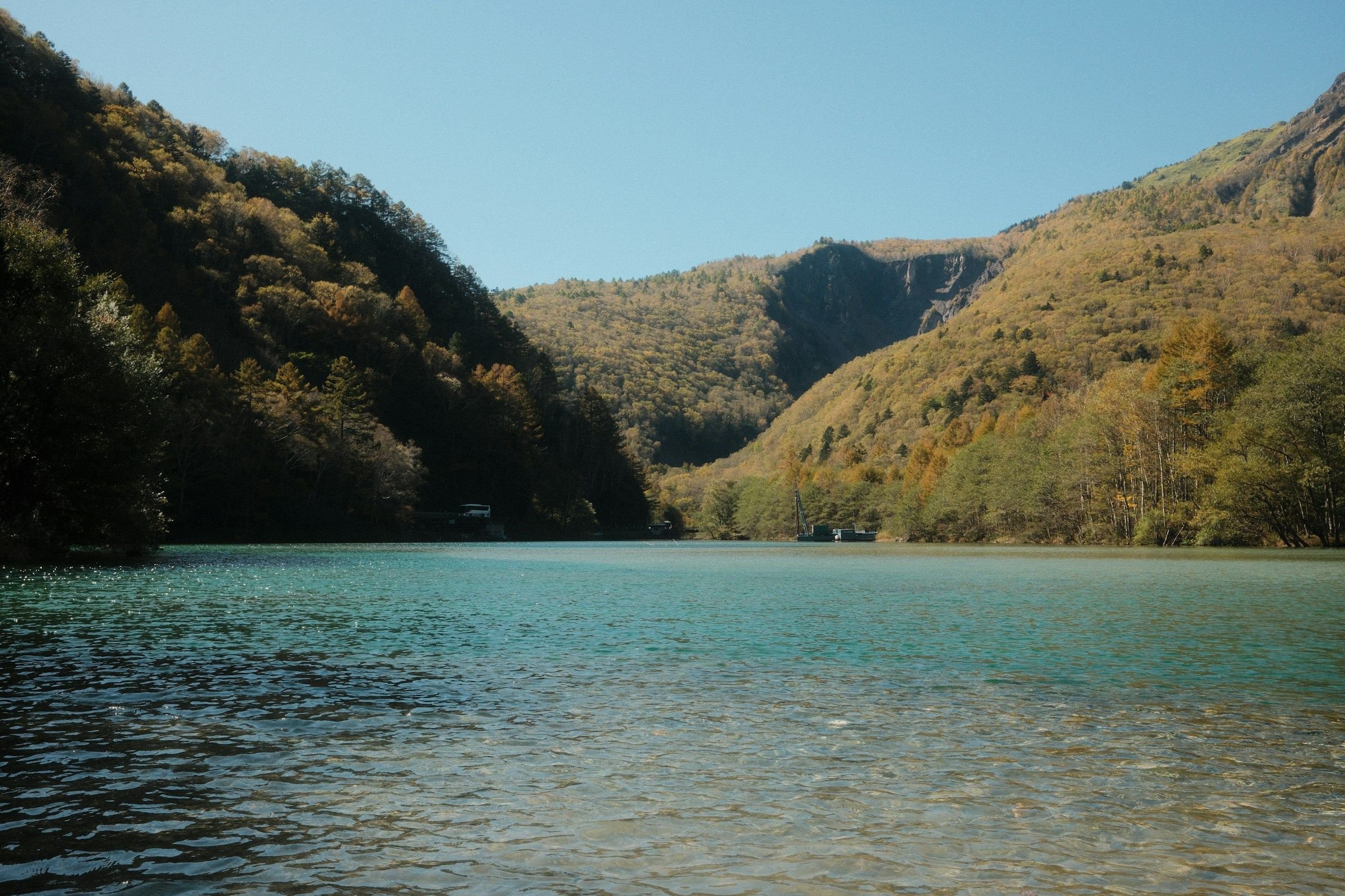 Danau alpine pegunungan Jepang dengan dedaunan musim gugur emas dan air biru kehijauan