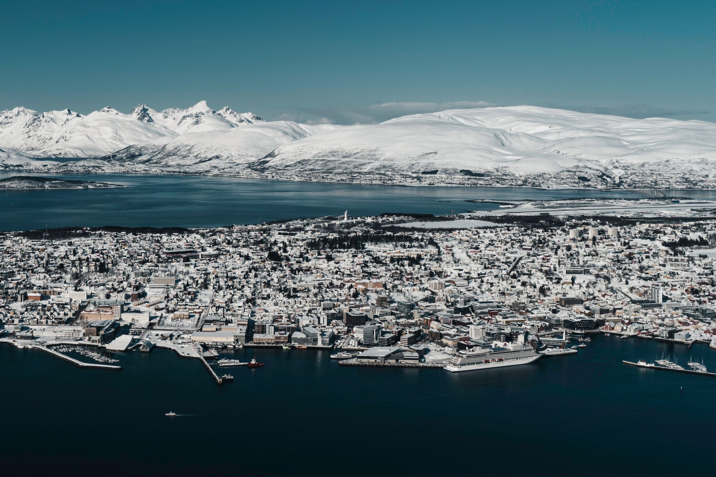Panorama kota Tromso yang bersalju dan fjord dari ketinggian.