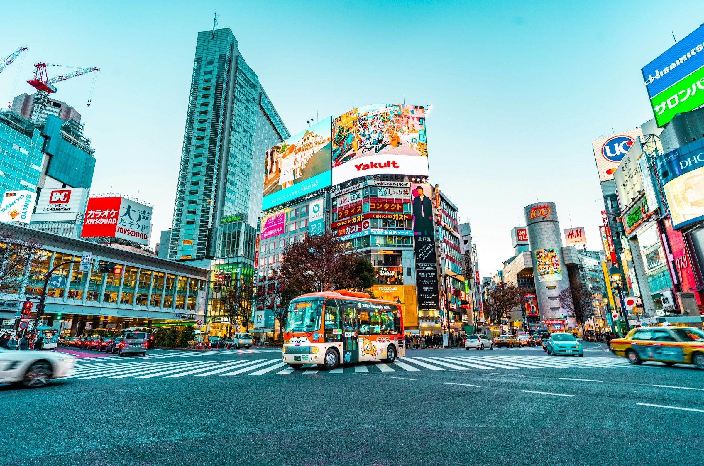 Shibuya crossing di jantung Tokyo dengan papan iklan neon dan gedung pencakar langit