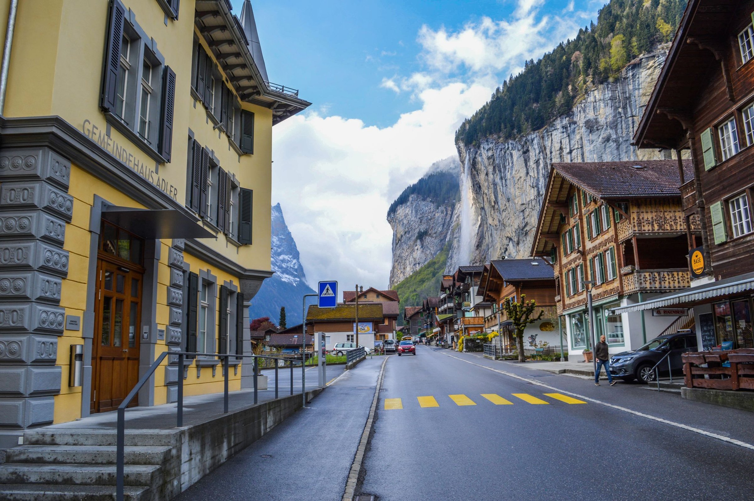 Sarah (Solo Traveler): Berdiri di jembatan pandang Lauterbrunnen Valley, air terjun Staubbach jatuh di belakangnya.