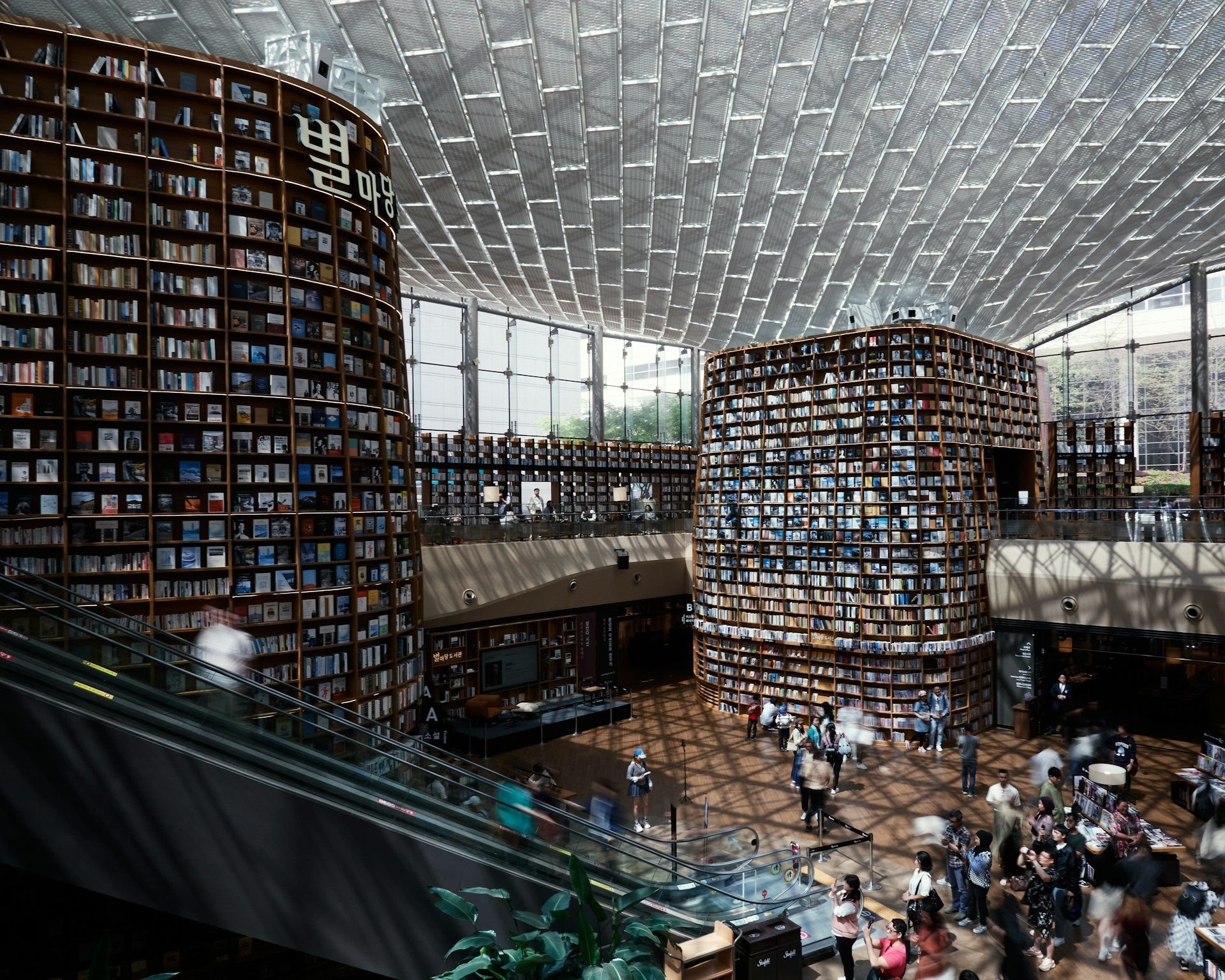 Interior Starfield Library COEX Seoul dengan dinding rak buku raksasa setinggi 13 meter membentuk atrium terbuka di pusat mal bawah tanah