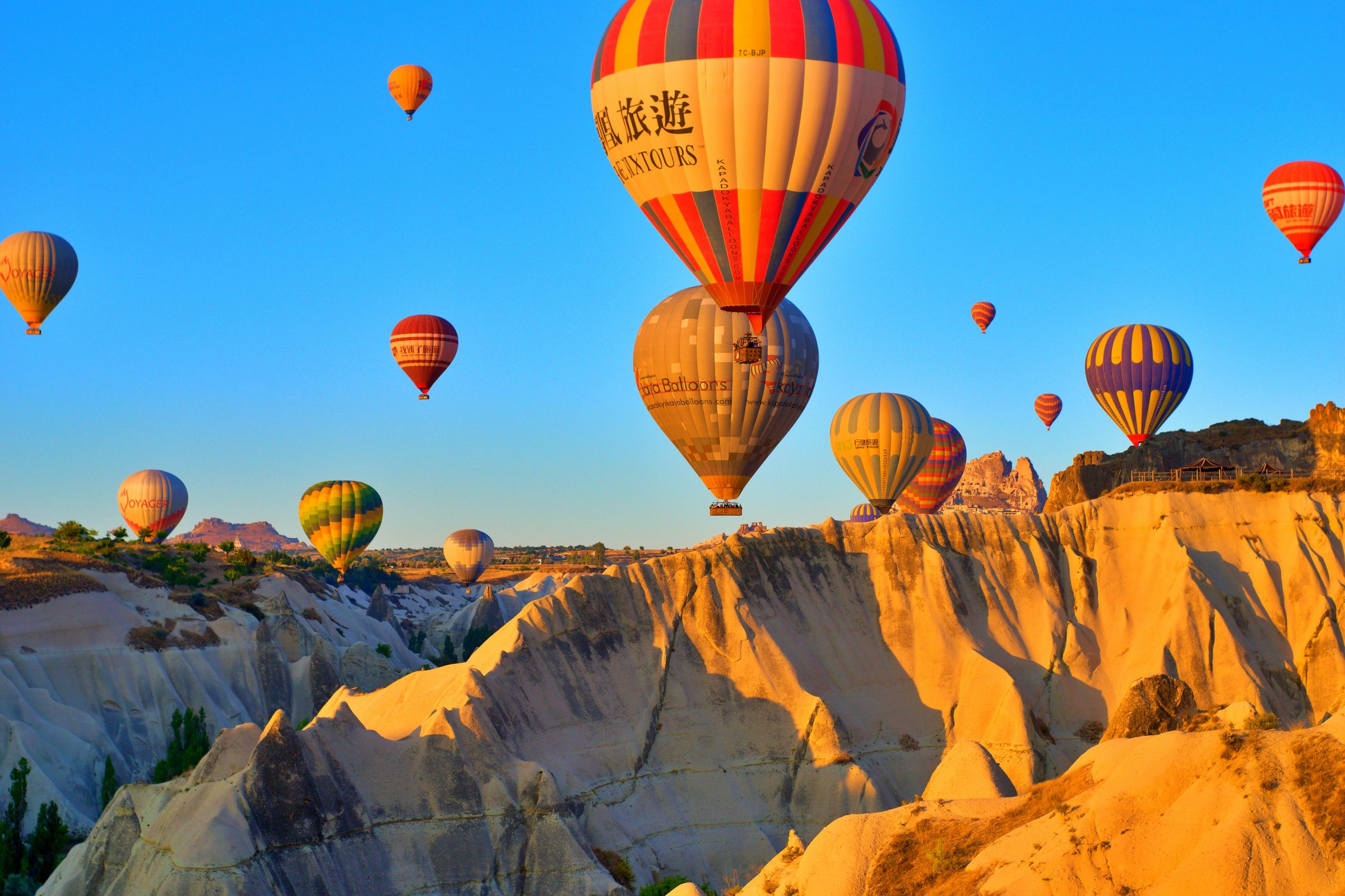Balon udara terbang di atas fairy chimneys Cappadocia saat sunrise