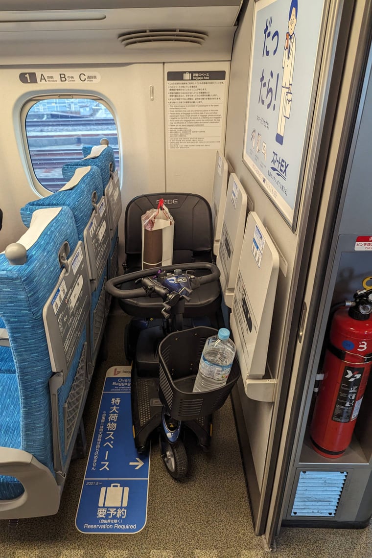 annedr-blog-shinkansen Anne's mobility scooter behind the last seats in the Shinkansen bullet train carriage