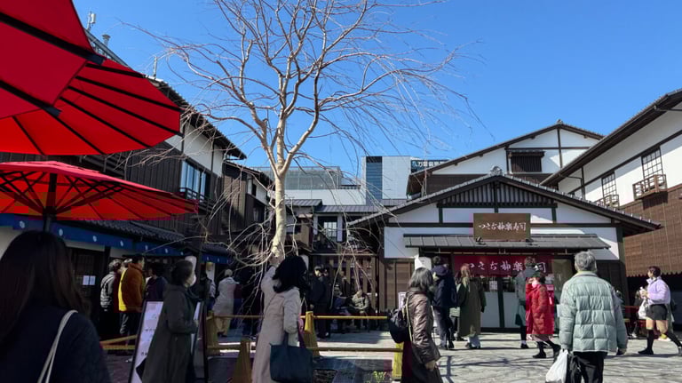 A lively courtyard at Toyosu Senkyaku Banrai, surrounded by traditional wooden buildings.