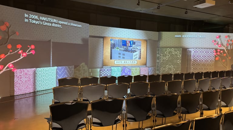 Projection mapping theater with visuals about the company's history and rows of chairs for visitors