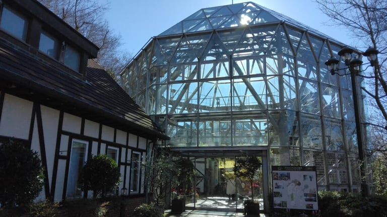Glasshouse at Kobe Nunobiki Herb Gardens, featuring a geometric glass exterior with a nearby Tudor-style building. Glasshouse at Kobe Nunobiki Herb Gardens, featuring a geometric glass exterior with a nearby Tudor-style building.