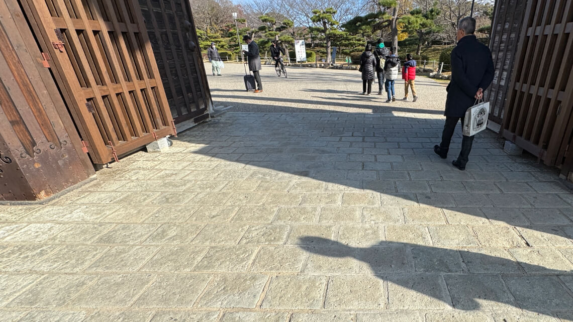 The castle gate opens to a slightly bumpy stone-paved pathway.