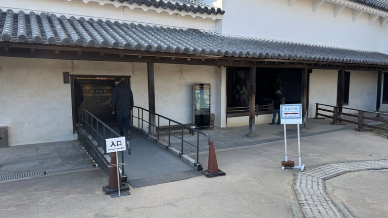 An entrance to the exhibition area with a ramp for accessibility, bordered by railings. An entrance to the exhibition area with a ramp for accessibility, bordered by railings.