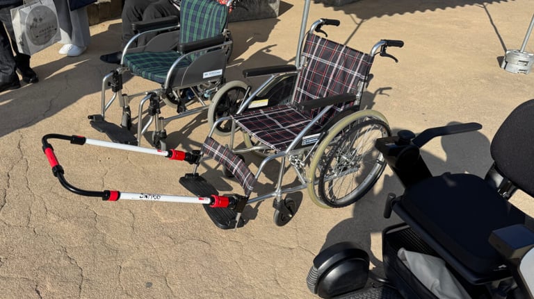 Closer view of the wheelchairs, with the middle one featuring front handles for pulling assistance on slopes. Closer view of the wheelchairs, with the middle one featuring front handles for pulling assistance on slopes.