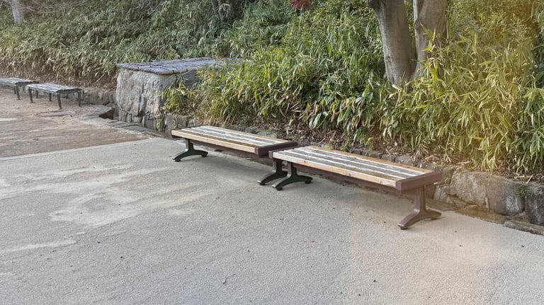 Wooden benches located along a smooth pathway, providing a resting spot midway through the garden route.