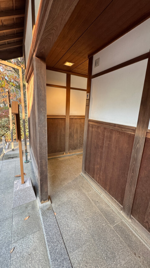 A narrow entrance to a toilet near the garden entrance, with a small bump at the threshold and a tight corner inside.
