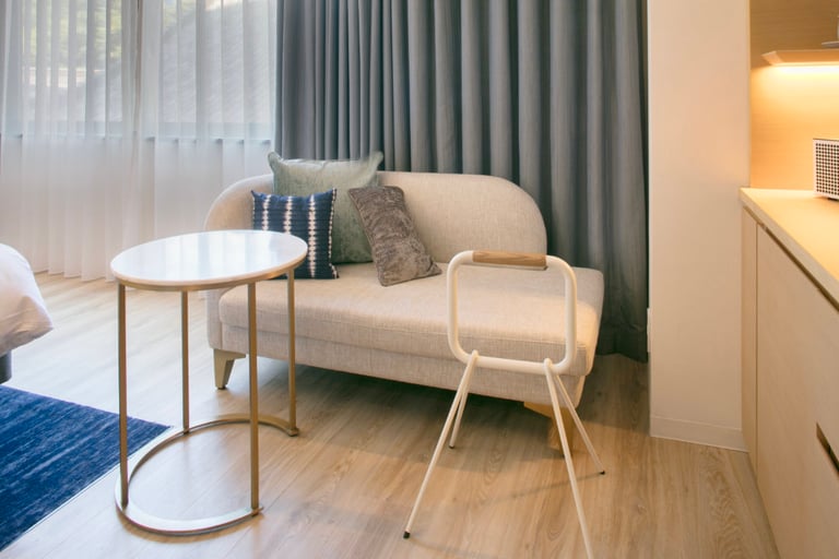 Cozy seating area with a cushioned bench, support rail, round table, and soft lighting, designed for accessibility.