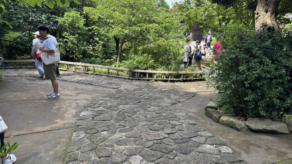 The stone-paved path is uneven with irregular surfaces, which may pose challenges for wheelchairs, strollers, or those with mobility issues.