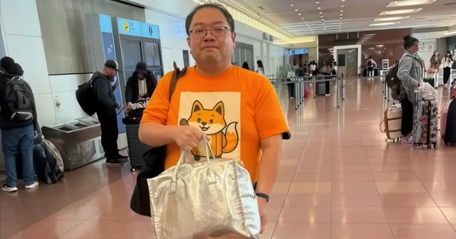 Hitoshi Asami at Tokyo airport arrivals wearing the distinctive orange shirt with fox character, ready to help customers with luggage delivery