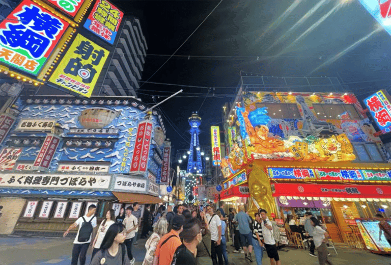 accessible osaka shinsekai evening tour neon lit street with tsutenkaku tower 768x521
