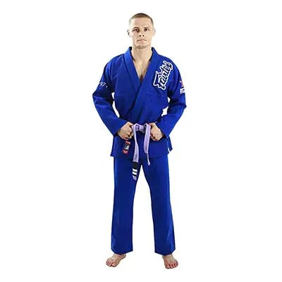 Một người đàn ông mặc bộ võ Jiu-Jitsu của Brazil màu xanh lam có nhãn hiệu Fairtex, đeo thắt lưng màu tím.