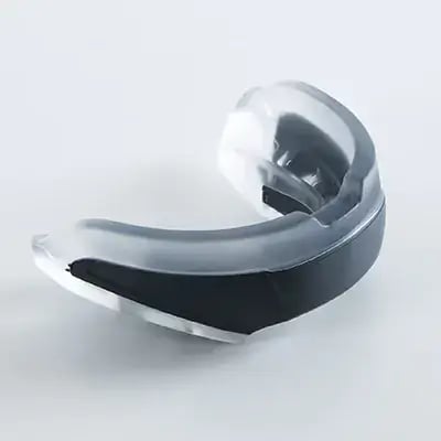 A contoured gray and black mouthguard offering tooth and concussion protection, suitable for athletes in contact sports.