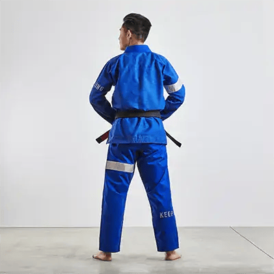 Mặt sau của một người mặc trang phục BJJ gi màu xanh lam với nhãn hiệu 'KING' ở mặt sau, thắt lưng đen.
