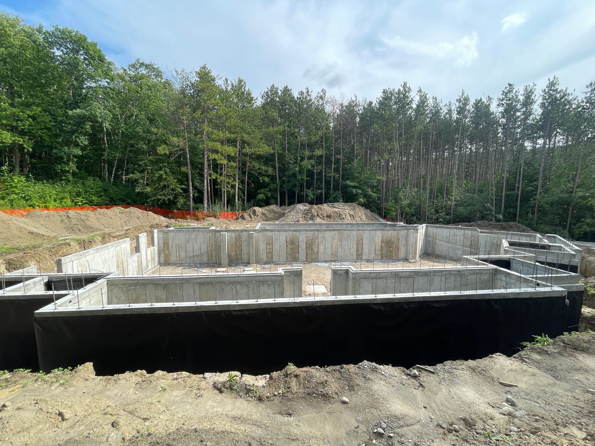Waterproofed residential foundation with black membrane coating in Aurora custom home construction