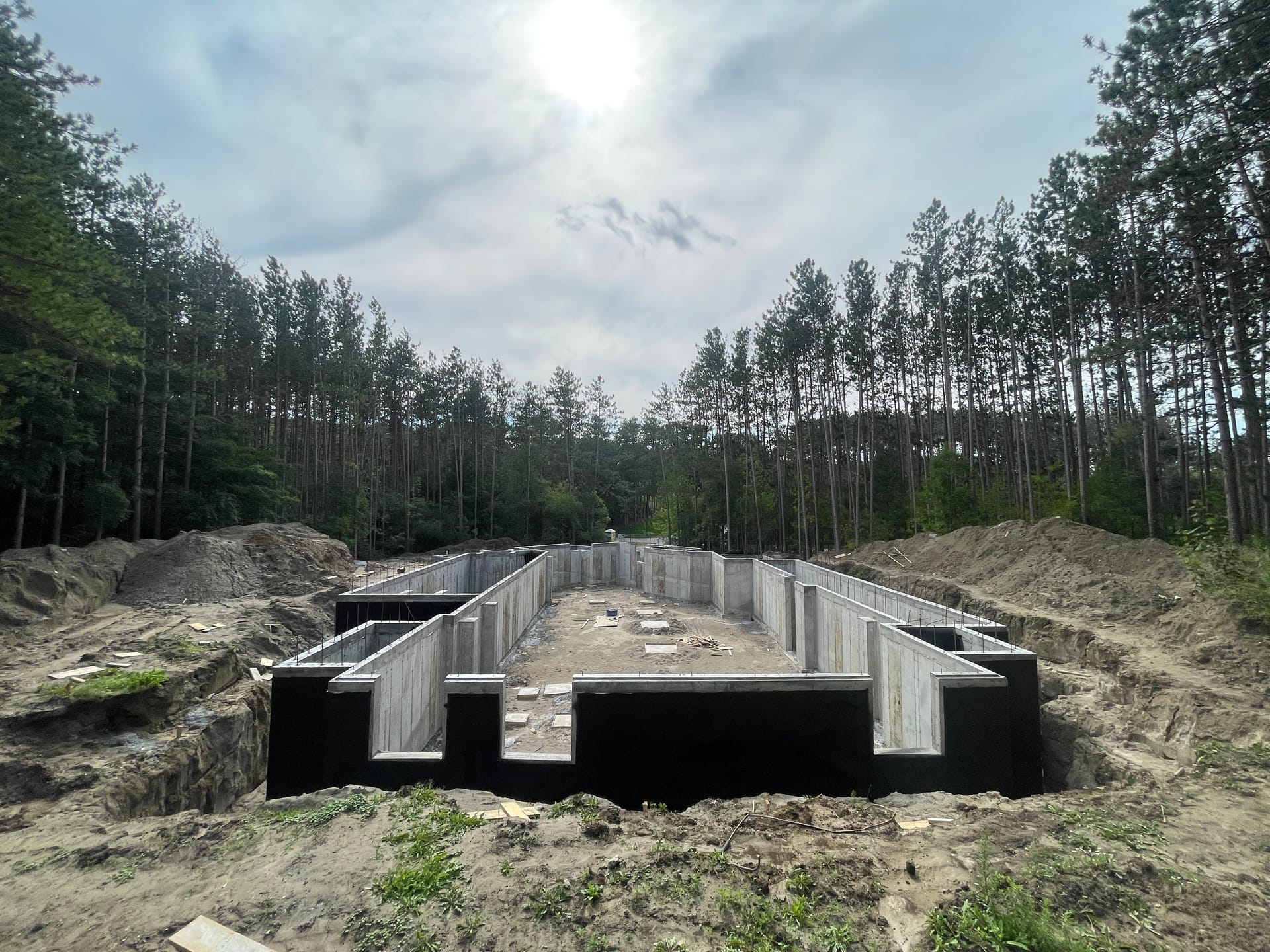 Black waterproofing membrane applied to concrete foundation walls Aurora residential construction project