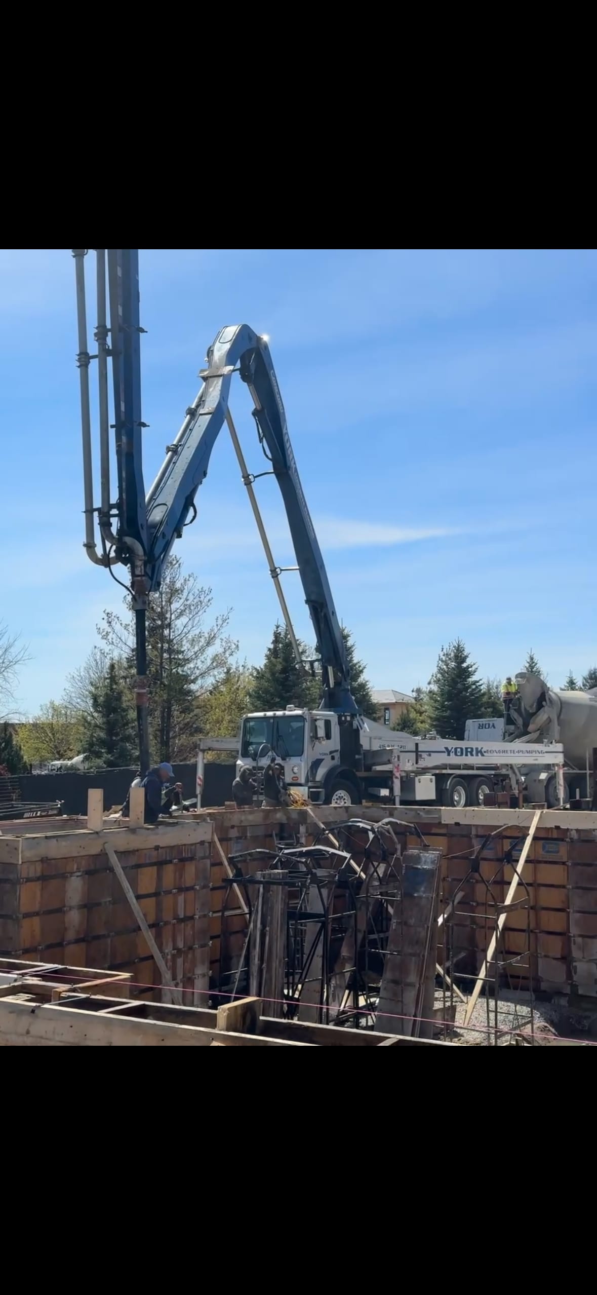 Concrete pump truck positioned at Brampton foundation site with braced formwork ready for pour