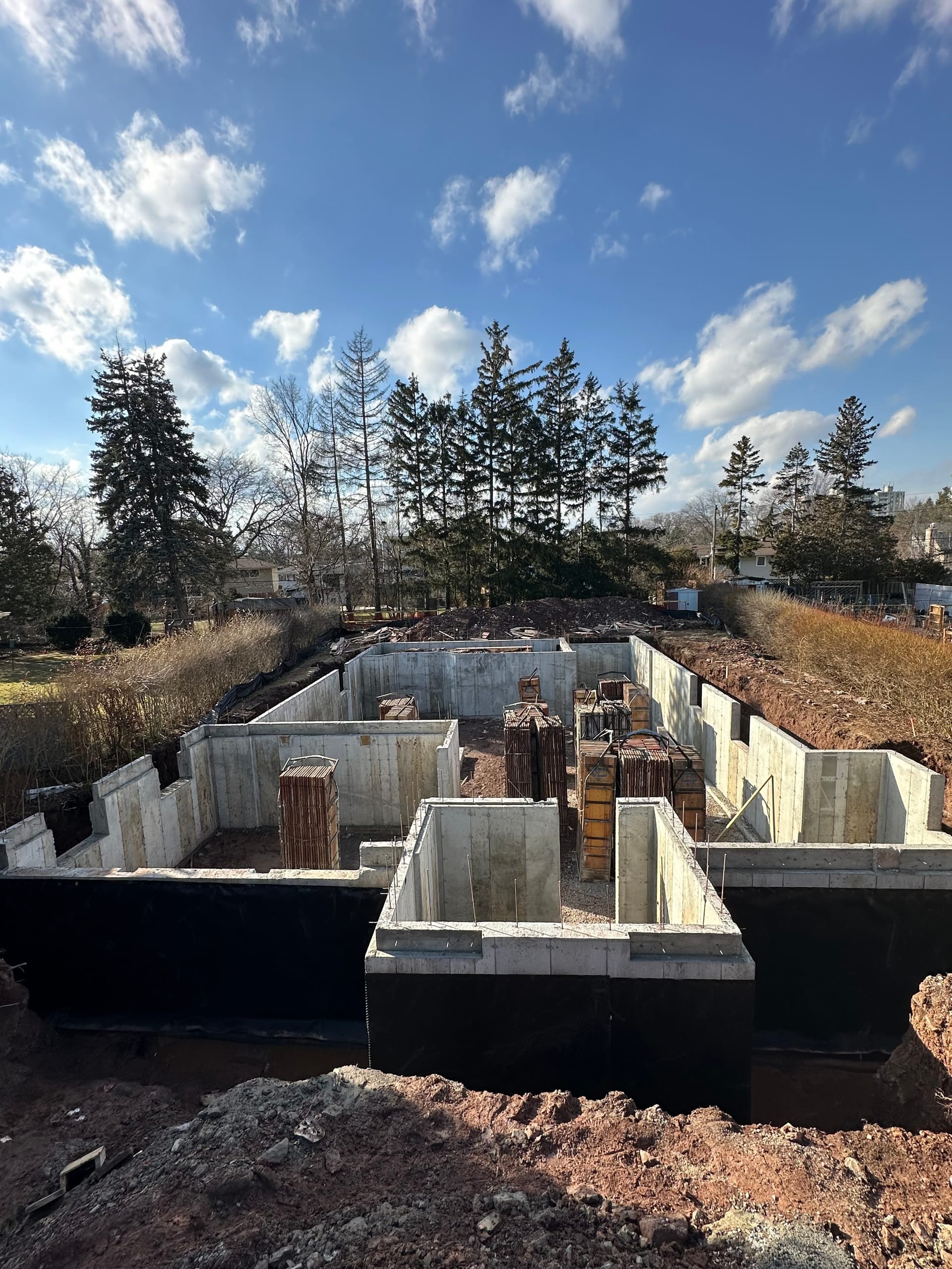 Concrete foundation walls with formwork, bracing, and reinforcement ready for pour in Burlington