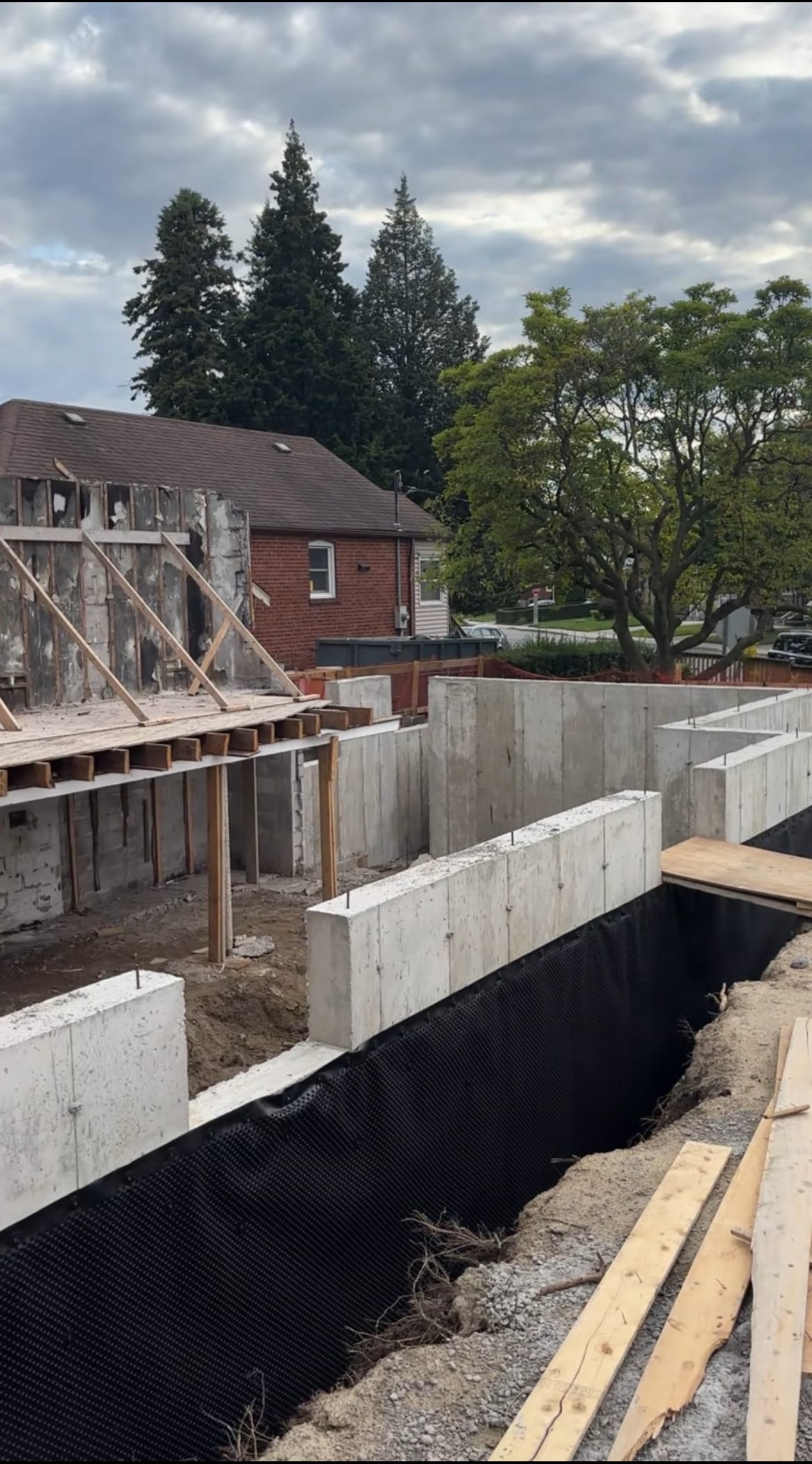 Completed foundation extension walls with black waterproofing membrane applied in East York residential project