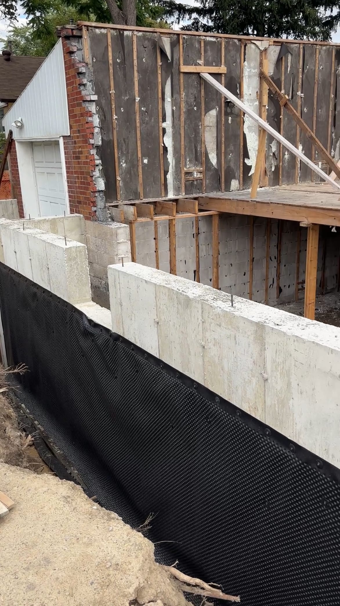 Stripped formwork reveals finished foundation extension walls ready for backfill in East York Toronto home