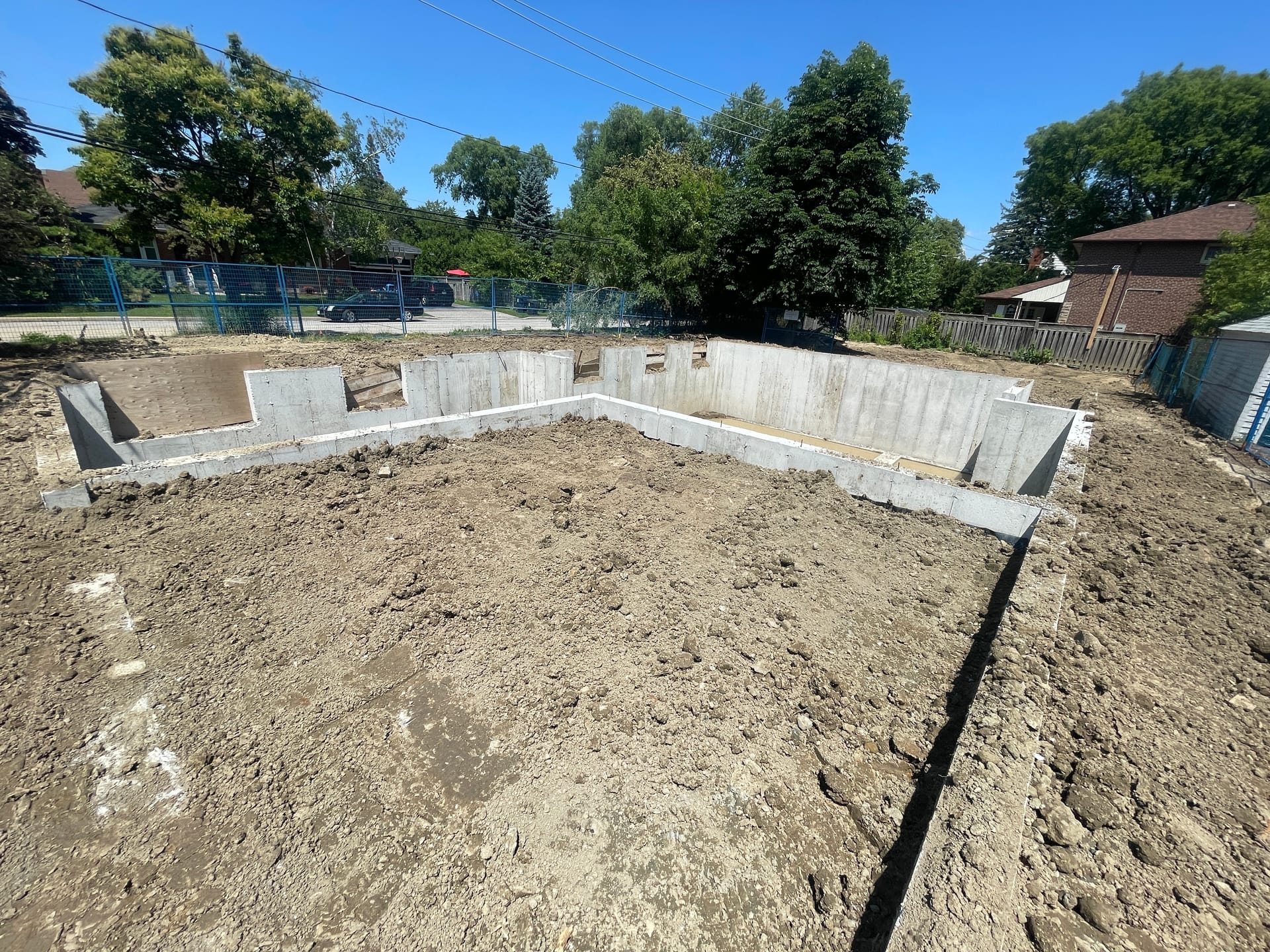 Completed residential foundation in Etobicoke after backfill showing grade-level concrete work