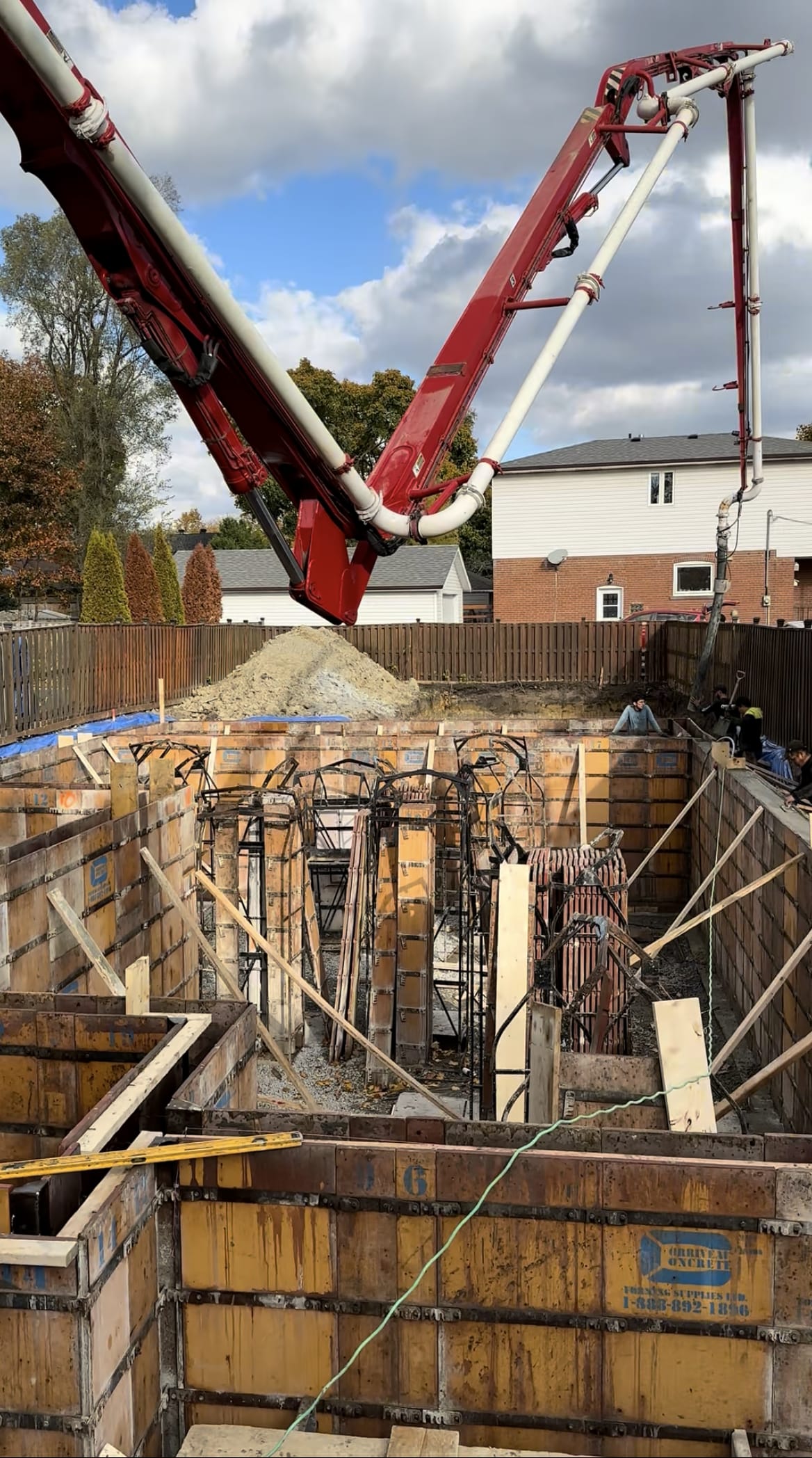 Concrete pump truck pouring foundation walls for Etobicoke residential extension project