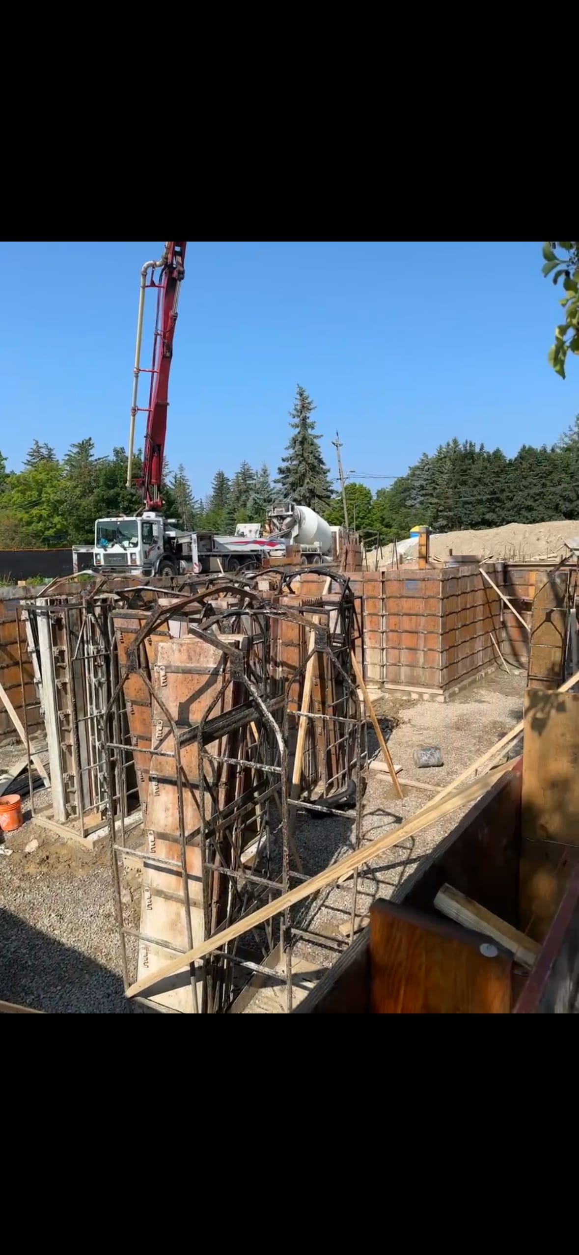 Concrete pump truck delivering fresh concrete to residential foundation site in Mississauga