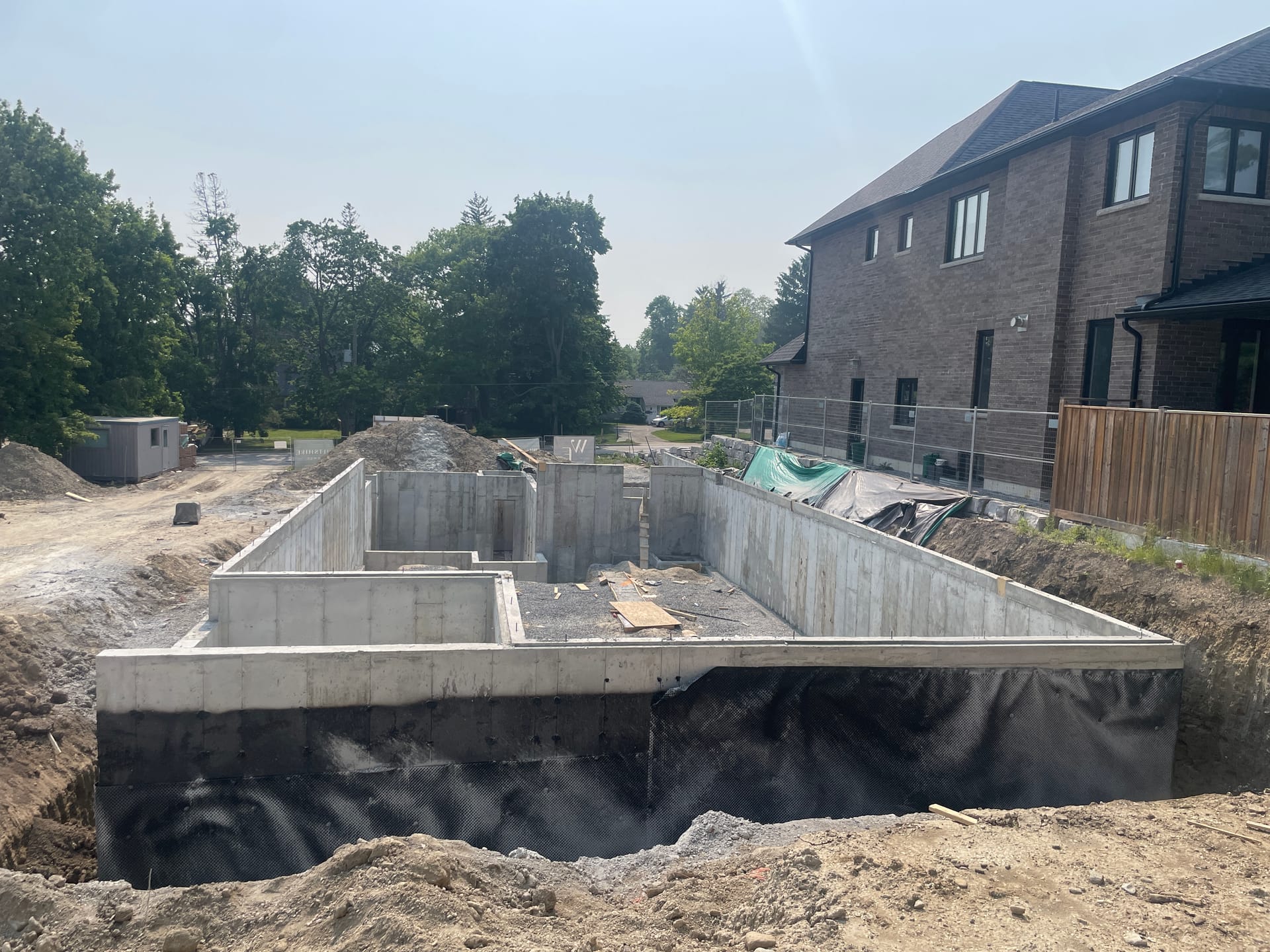 Completed Pickering foundation walls with waterproofing membrane application nearing completion