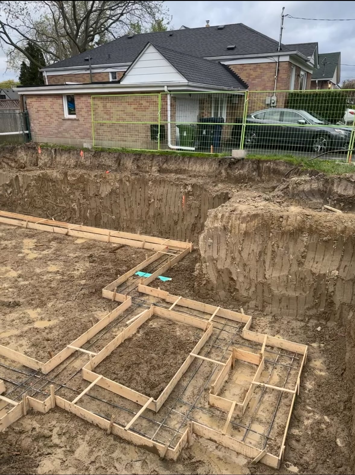 Concrete pump truck filling foundation walls during pour at Scarborough residential project