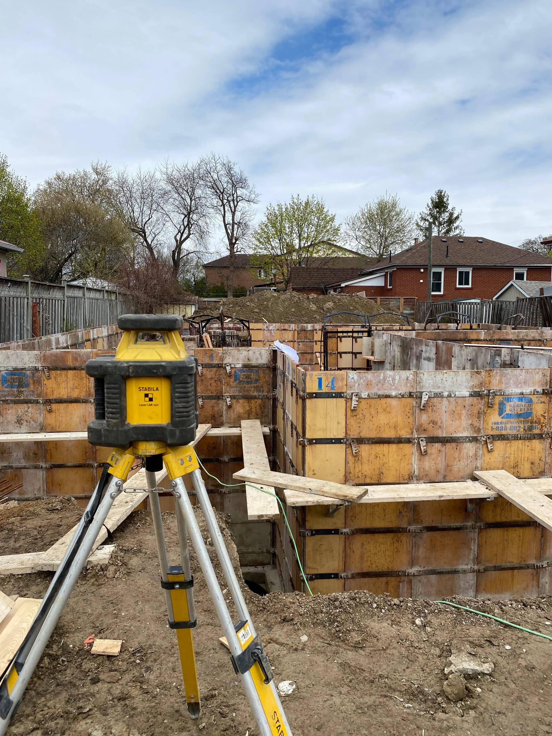 Scarborough foundation walls being stripped after concrete pour with steel cages loaded on site