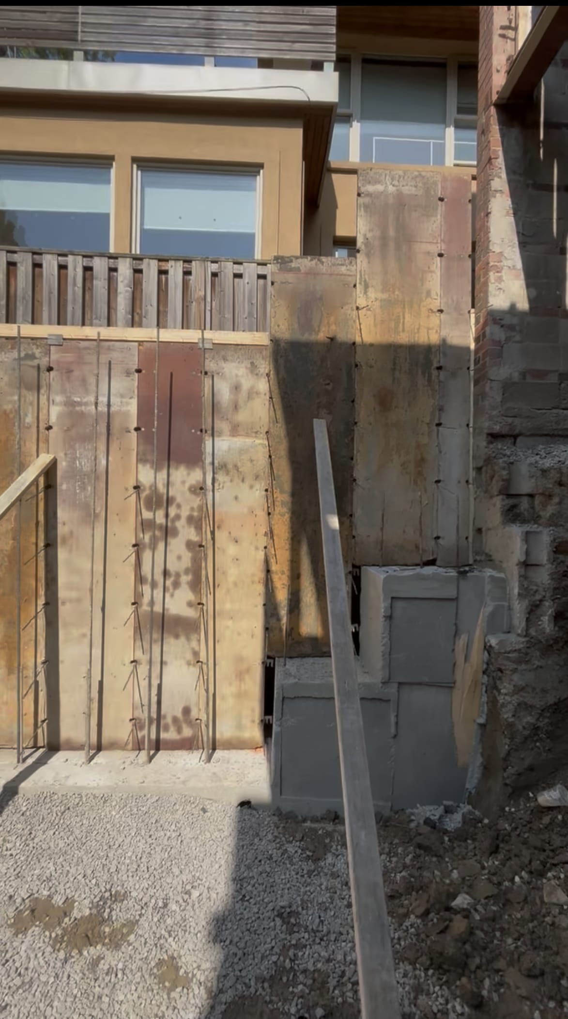 Completed foundation extension walls in Toronto with waterproofing membrane application in progress
