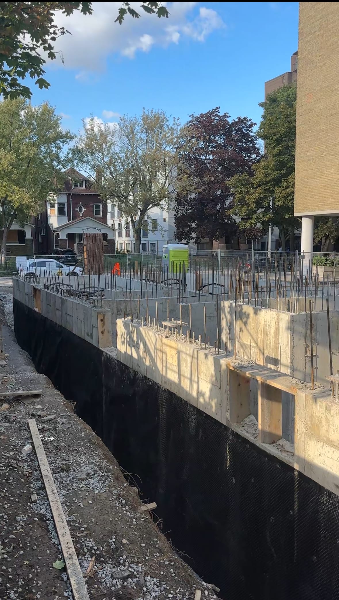 Toronto six-storey multiplex foundation walls showing completed concrete work and waterproofing application