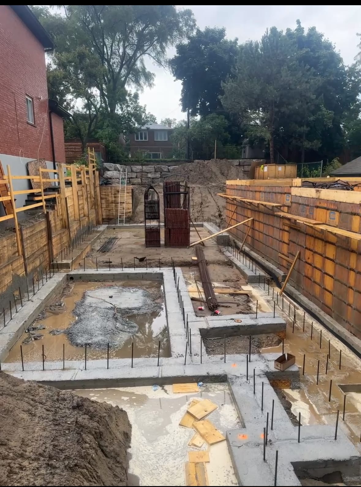 Formwork removal revealing completed foundation walls for two Toronto homes side by side