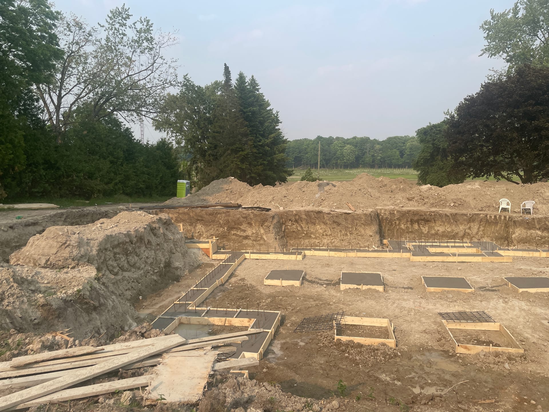 Exposed concrete foundation walls after form removal on Whitby residential construction site