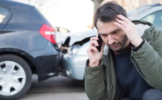Man on phone after car accident