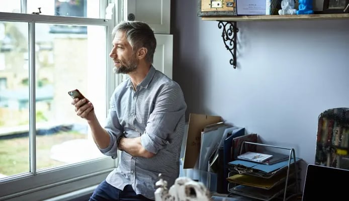 Man gazing out of a window contemplating under settling a claim