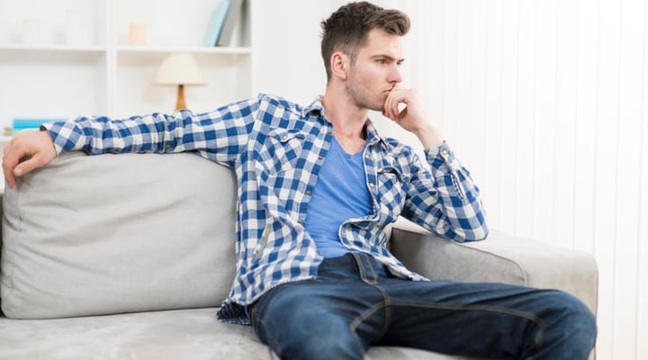 Man on sofa thinking about going back to work