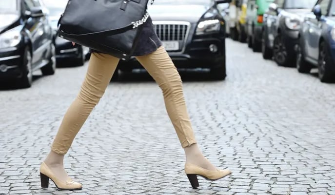 Woman crossing the road in danger from an approaching car