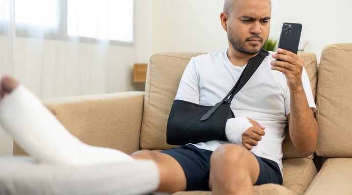 Man with broken leg and arm on sofa