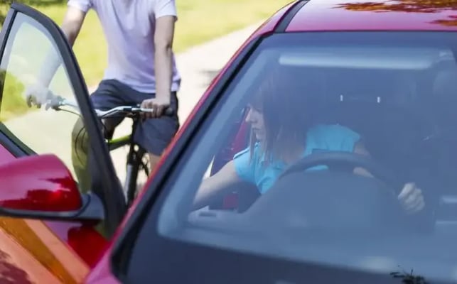 Driver opening their car door into the path of a cyclist