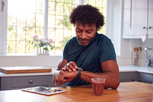 Man sitting down checking his fitness activity tracker