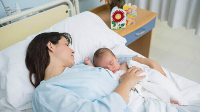 Mother and her baby in a hospital bed