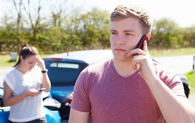 Man on phone after a crash with an uninsured driver