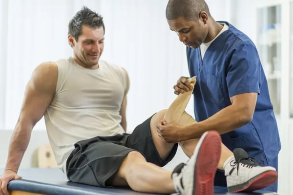 Man with injured knee with physiotherapist